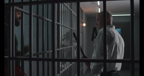 Angry Prison Officer Watches Criminals in Prison Cells
