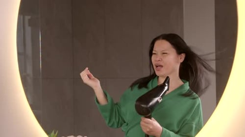 Woman Singing and Styling Hair with Hairdryer