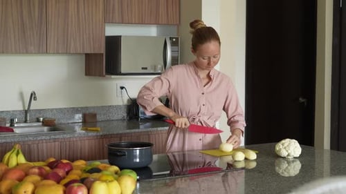 Woman Chopping Potatoes in a Bright Kitchen