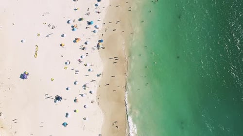 A crowd of people vacationing and enjoying themselves at the beach