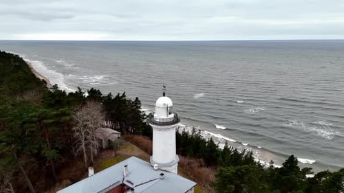 Ein Leuchtturm in Uzava befindet sich an einer felsigen Ostseeküste, im Hintergrund ein großes Gewässer.
Das