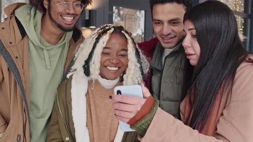 Freunde schauen sich etwas auf dem Smartphone an
