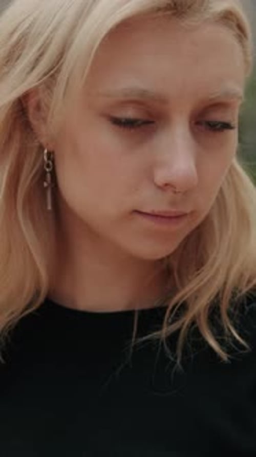 Vertical video, Serious Young Blonde Woman in a Close Up
