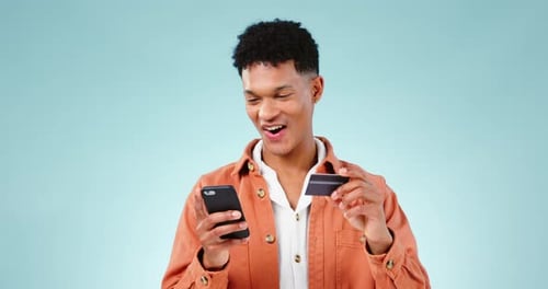 Man, smartphone and credit card with e commerce and payment success in studio on blue background