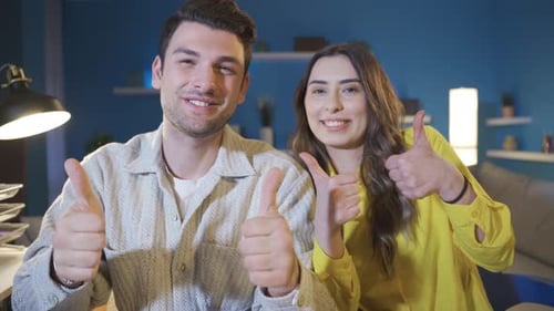 Cheerful Couple Smiling and Waving Indoors