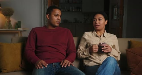 Couple Chatting and Laughing on Sofa at Home