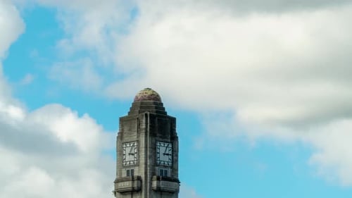 Uhrenturm tickt Zeit mit Wolken, die sich auf blauem Himmel bewegen, Zeitraffer