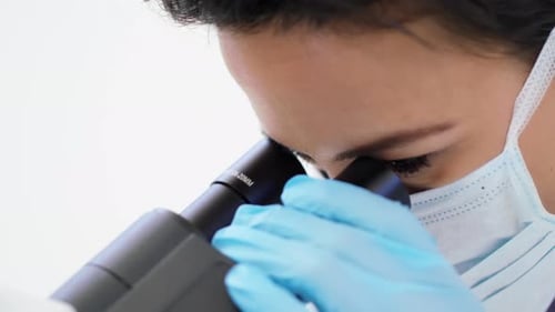 Woman Using Microscope in Medical Lab Close Up