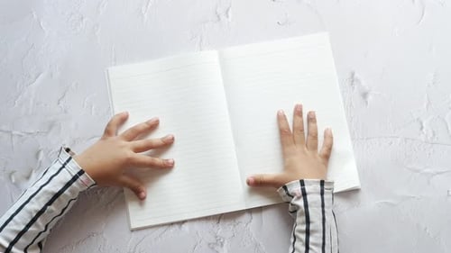 Top View of Child Hand Turning a Pager of a Diary