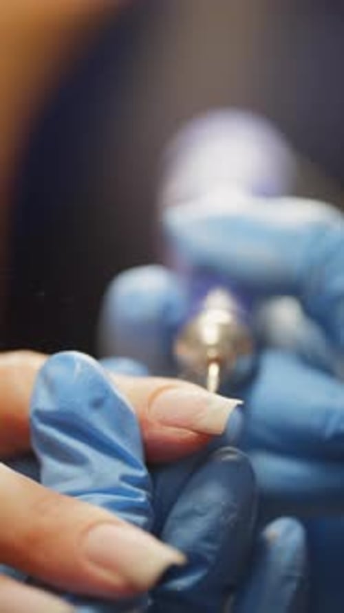 Manicurist Buffing Fingernail with Electric File Close Up