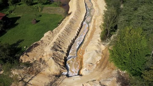 Aerial view of acidic mine residual water drainage, flowing into decanting pond