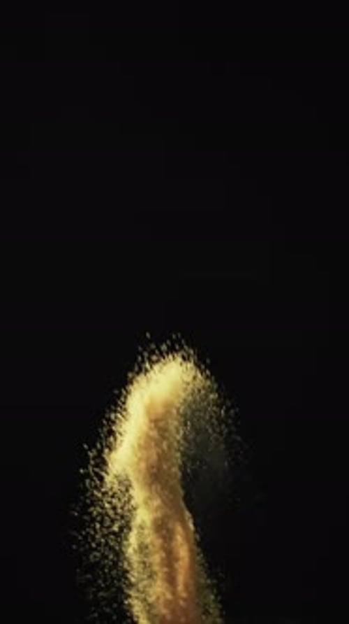 Vertical video of white sand grains thrown in air and copy space on black background