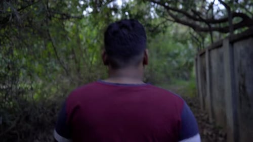 man walking in the deep jungle from the back