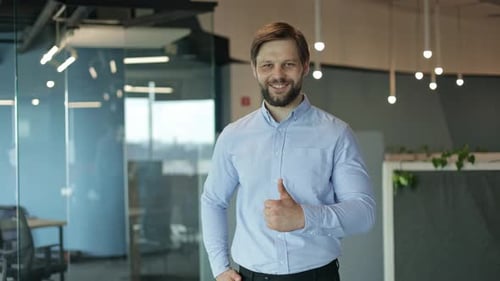 Confident Businessman Giving Thumbs Up in Office