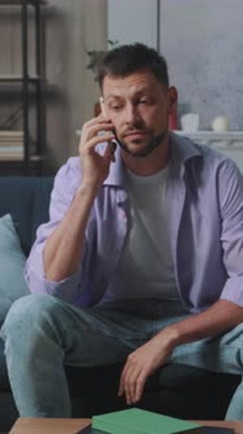 Man Talking on Mobile Phone in Living Room