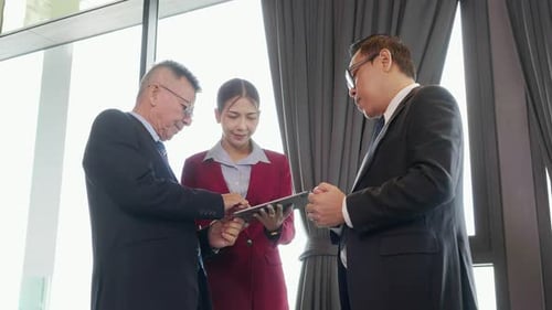 Business People Discussing Work Using Tablet in Office