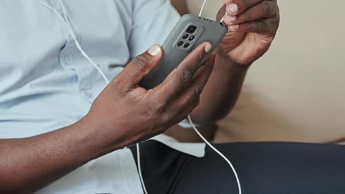 Adult Connecting Headphones to Phone Indoors