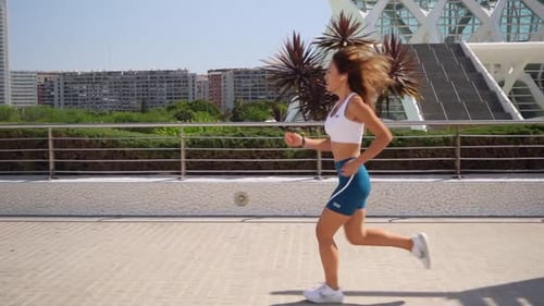 Asian Adult Woman Jogger in Sportswear Running Workout Sunny Morning Urban High Tech City Futuristic