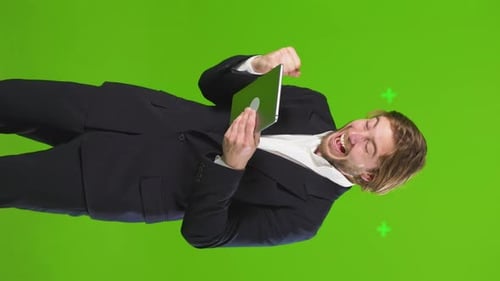 Man Celebrates Tablet Success on Green Screen