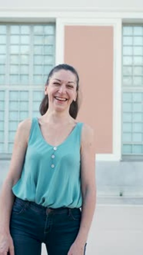 Woman looking at camera and smiling in the street.