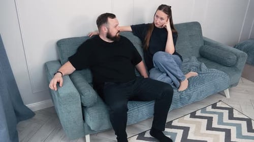 Pareja conversando en el sofá de la sala de estar