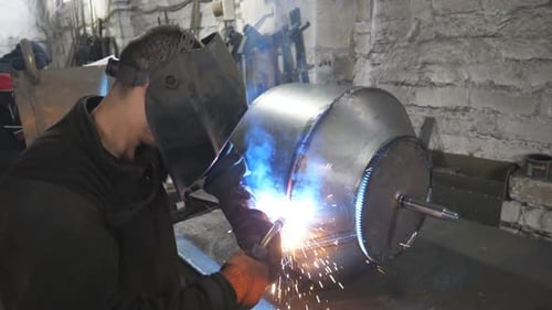 Worker in Protective Mask Welding Metal Construction at Metalworking Factory