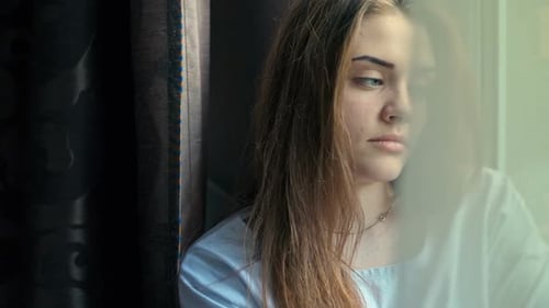 Woman Looks Thoughtfully out the Window