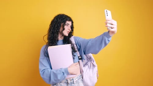 Smiling Woman Takes Selfie with Phone and Backpack