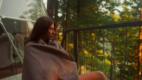 Woman Covers with Blanket on Terrace of Glamping House