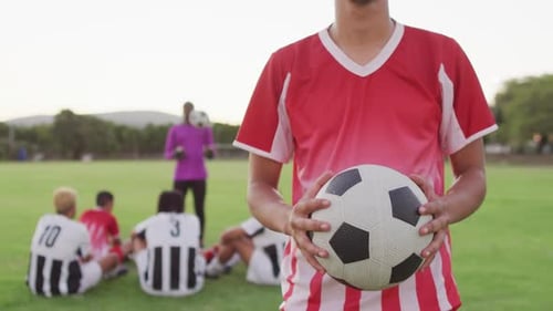 Video of biracial football player on field with ball