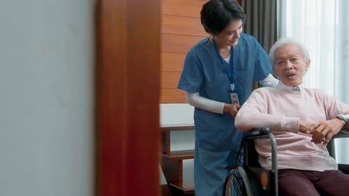 Kind Nurse Supporting Elderly Patient in Wheelchair