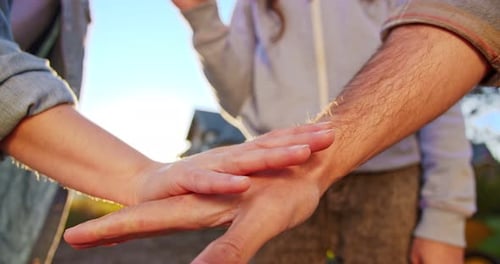 Kaukasischer Vater, Mutter und Kind legen sich nach Beendigung der Gartenarbeit die Hände aufeinander