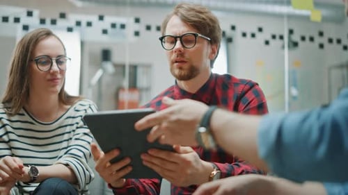 Team Collaborating on Tablet in Modern Workplace