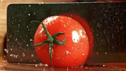 A Knife Cuts a Tomato with Splashes Filmed on a Highspeed Camera at 1000 Fps