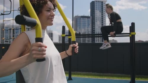 Woman Exercising on Push Pull Chair Fitness Equipment at Rooftop Gym