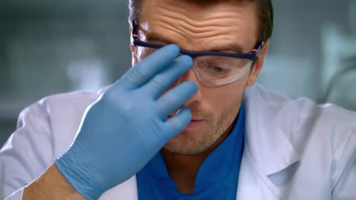 Scientist Corrects Glasses. Portrait of Scientist Focused on Work. Scientist Face Close