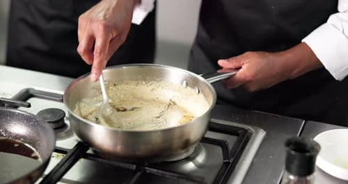 Chef Cooking Delicious Creamy Sauce in Stainless Pan