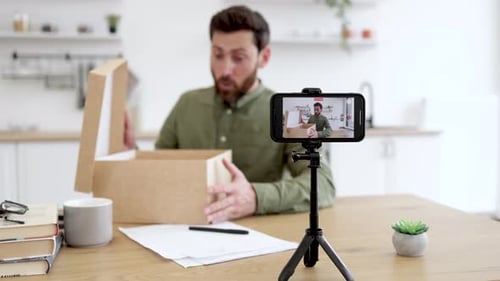 Man Unboxing a Package While Recording Video