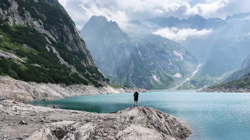 Hiker Reaching the Shore of an Alpine Turquoise Lake