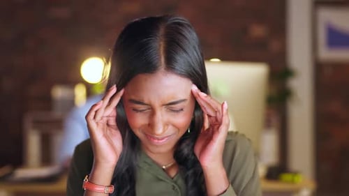 Woman, headache and stress at night in burnout, overworked or anxiety at the office desk