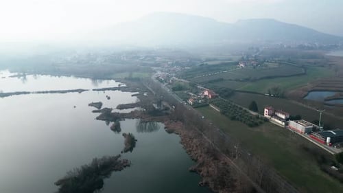 Los vehículos circulan por una carretera junto al lago