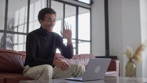 Man on Couch Video Calling on Laptop