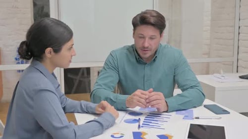 Business Discussion Between Man and Woman in Workplace