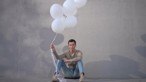 Young Adult With Balloons In Urban Setting