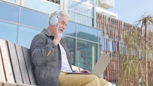 Senior Man Using Laptop on Park Bench