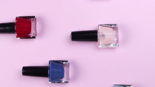 Collection of Colorful Nail Polish Bottles on Pink
