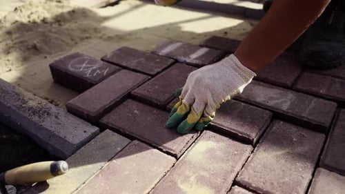 Worker Laying Bricks with Rubber Mallet