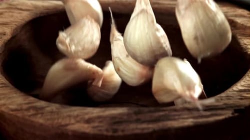 Garlic Falls Into a Wooden Plate Filmed on a Highspeed Camera at 1000 Fps
