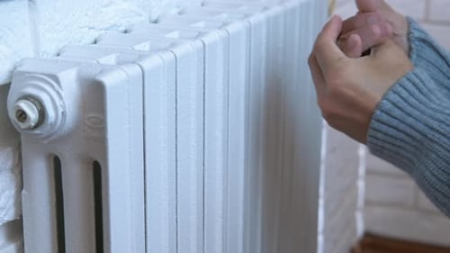 Hands on Radiator During Heating Season