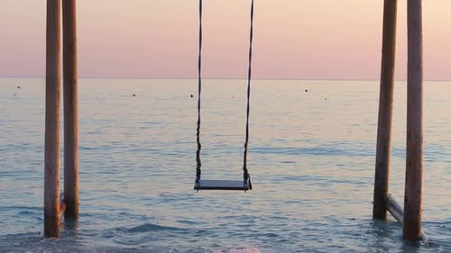 Wooden swing on the beach sunset